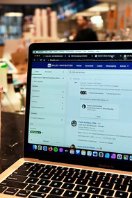 A laptop rests on a table, ready for work in a cozy café setting