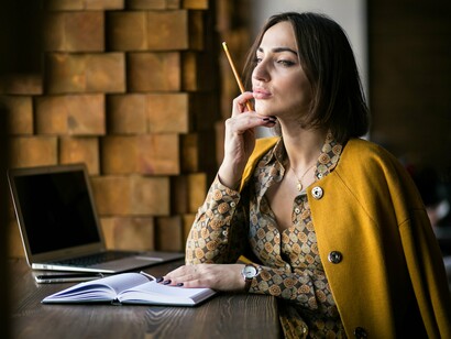A woman contemplating her next words, reflecting the shift from seeking love in others to finding it in the stories she writes