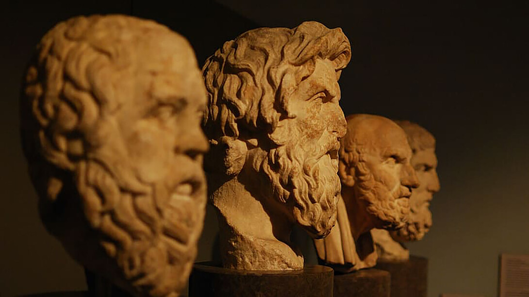 A photo of four philosophical busts, featuring Aristotle and other great thinkers, capturing the essence of timeless wisdom