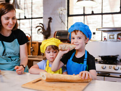 A mother cooks with her children in the kitchen, capturing the joy of kids cooking together