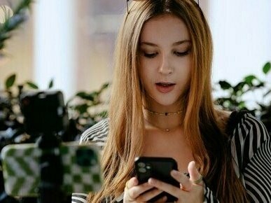 Jovem registra seu cotidiano para criar conteúdo. O comportamento humano permanece fundamentalmente o mesmo, mas o paradigma da narrativa sofreu uma alteração substancial. A curadoria da edição televisiva desapareceu, e um fluxo constante de conteúdo, muitas vezes sem critério estético ou de bom senso, é despejado nas redes sociais