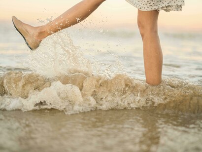 Women splashing water with her foot, reminding us that joy hides in moments we overlook 