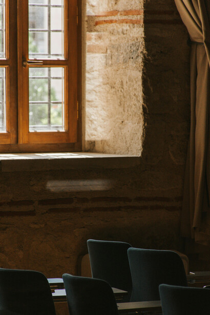 Rows of empty chairs in a university lecture hall, echoing the absence of voices that once sought truth and understanding