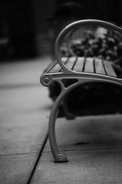 A lonely bench stands vacant, surrounded by empty streets, embodying a quiet sense of melancholy solitude