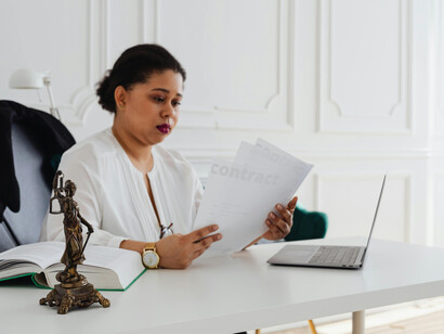In her office, a lawyer carefully reads legal documents at her desk