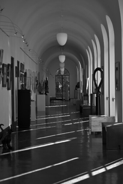 An empty art gallery captured in black and white, evoking a sense of stillness and solitude