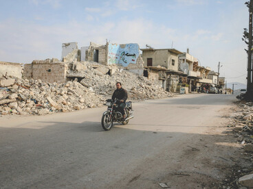 Idlib, Idlib Governorate, Syria. An unidentified biker passes through a neighborhood of demolished homes after years of conflict