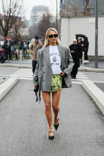 In Milan’s cityscape, a woman showcases chic street style with an oversized blazer