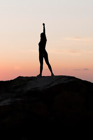 Woman holding her arm up in success, symbolizing learning from mistakes, self-discovery, and personal growth