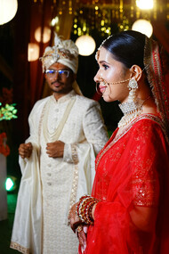 A radiant bride and groom celebrating a traditional Kumaoni wedding, adorned in vibrant attire and cultural splendor