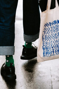 Una chica sostiene su 'tote bag' blanca. 'Tote' viene del verbo 'to tote', que significa «llevar»