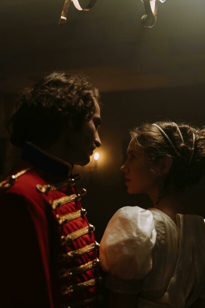 An aristocratic couple dancing in a candlelit room, wearing elegant 18th-century fashion