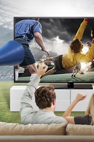 Grupo de amigos sentados en el sofá viendo el fútbol por televisión