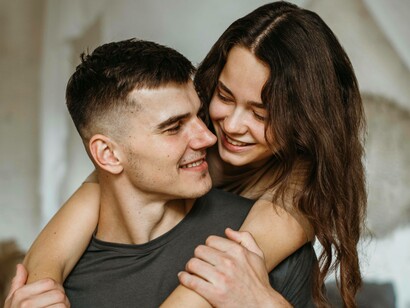 Una giovane coppia che si abbraccia e si guarda con affetto