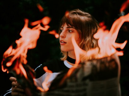 As a girl burns a newspaper, the flames become a striking symbol of resisting and exposing disinformation