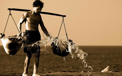 Uomo che tiene in equilibrio sulle spalle due ceste cariche: "Questo tempo moderno ci permette di vivere vite comode e di assecondare la gratificazione immediata, eppure senza impegno, senza fatica, senza sacrificio non c’è crescita"