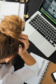 Woman with her hands on her head at her work desk