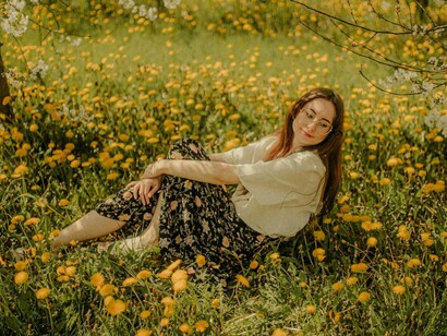 Mulher em campo de flores. A juventude sempre foi a sua principal moeda de troca, e, ao atingir os 40 anos, ela se vê questionada, muitas vezes invisibilizada. Não é mais a “garota” da vez, nem a jovem promissora. Agora, ela se vê com outros rótulos: a mulher experiente, a madura, a que já não pode se dar ao luxo de ser espontânea
