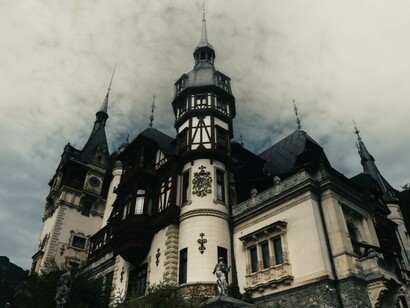A large spooky castle with a clock tower in Romania