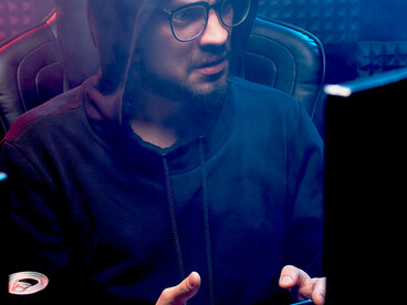 Alone at his computer, a man navigates the emotional toll of online spaces plagued by hate speech, cyberbullying, and social media harassment—key threats to digital dignity in today’s connected world