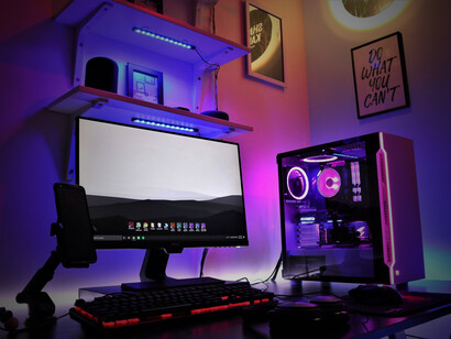 A computer setup with headphones and a smartphone on the desk, featuring a gaming PC