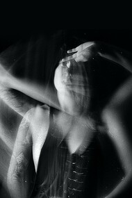 Jovem perturbada tocando o rosto na escuridão