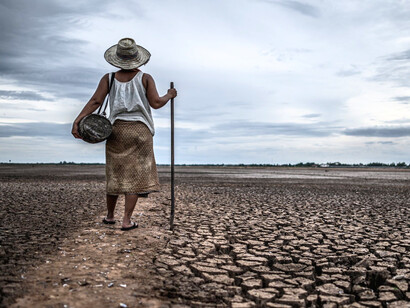 A man walking on a drought-stricken land, reflecting the growing crisis of water insecurity and climate stress