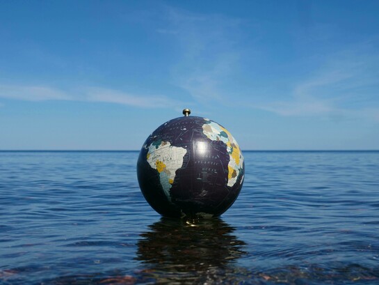 A fragile world adrift; where the fate of the planet floats between calm waters and an uncertain sky