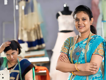 A South Asian mother balancing childcare and remote work, representing the invisible economy of care