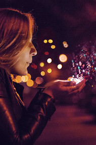 A girl blowing sprinkles into her hand, signifying magic