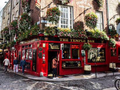 A vibrant red building with lush plants covering its rooftop, situated in the lively Temple Bar district of Dublin, Ireland