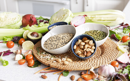 Close-up of a bowl of chia seeds surrounded by other healthy superfoods on a kitchen table