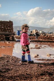 A child, who lives in poverty, stood alone by a puddle. Re-editing failed revolutions and ideologies is an understandable practice because of the permanence of oppression and inequality