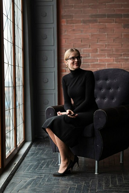 A sophisticated woman seated on a couch, showcasing timeless old-money elegance
