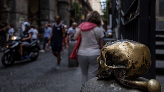 Spaccanapoli, in primo piano il teschio in bronzo posto all'ingresso della chiesa Santa Maria delle Anime del Purgatorio ad Arco, Napoli, Italia