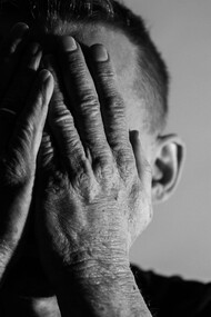 A man touching his face in depressed mode