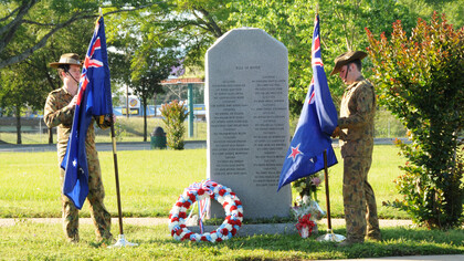 Australian service members stand before the 135th Assault Helicopter Company memorial in Veterans Park on April 25, following the Anzac Day ceremony honoring the Australian and New Zealand Army Corps who fought at Gallipoli during World War I