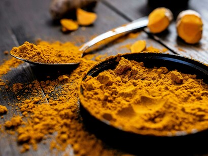 Close-up shot of turmeric powder and fresh turmeric root