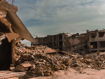 Aleppo, ravaged by the Syrian conflict, presents a grim scene of ruined buildings and a war-devastated landscape, reflecting the deep scars of the war
