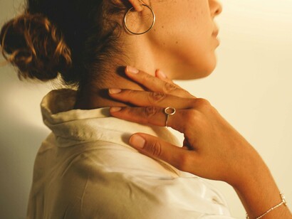 A woman gently massages her neck, highlighting a mindful stretch that helps ease tension from anxiety first thing in the morning