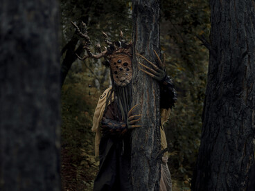 Mysterious figure emerging among trees at night, symbolizing the human tendency to project meaning onto the unknown