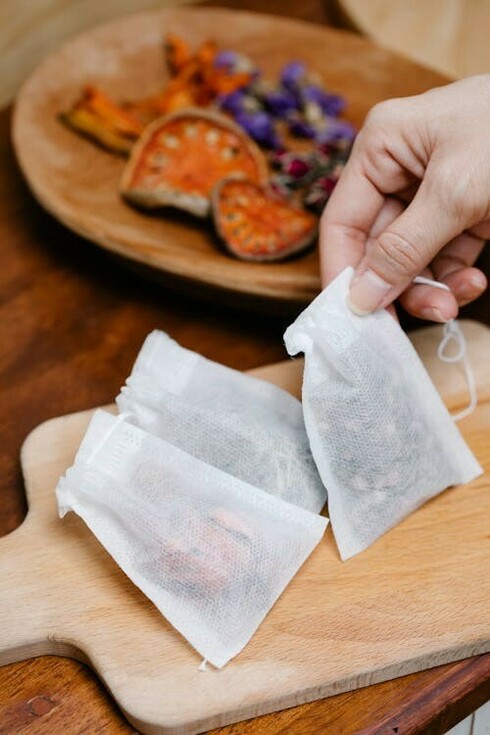 A person organizing dried Ayurvedic herbs into packages, representing the connection between Prakriti, Ayurveda, and personalized medicine in promoting health