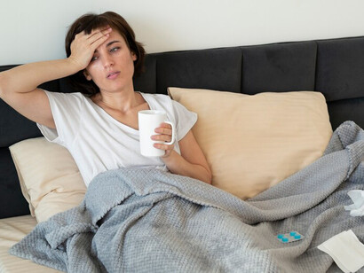 A woman lying in bed, experiencing chronic illness, fatigue, exhaustion, and thyroid dysfunction