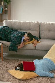 Husband and wife living a sedentary lifestyle, lounging on the couch with little movement