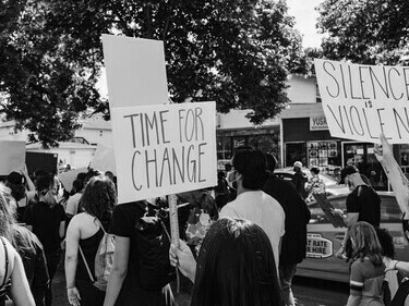 Jovenes protestan por los derechos humanos y la justicia social y escriben que es "Tiempo de cambios" y "Silencio es violencia. R. U. 