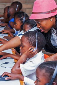 A teacher guides students through the digital landscape, showcasing South Africa's commitment to leveraging technology for inclusive learning and skill development