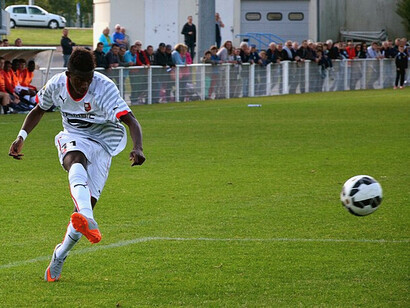 Ousmane Dembélé, centrant du pied droit, lors d'un match du Championnat de France de football national opposant le FC Saint-Lô au Stade rennais