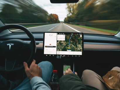 A man sitting in a car is checking the GPS on the dashboard