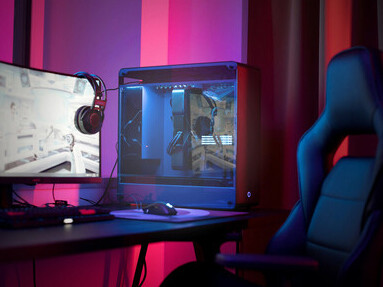 A desk setup featuring a computer, headphones, and a smartphone