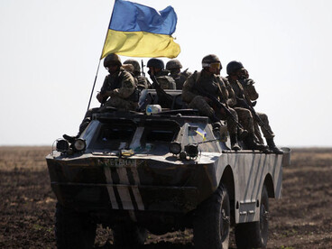 Ukrainian conflict showing military tanks, armed soldiers, and deployed troops